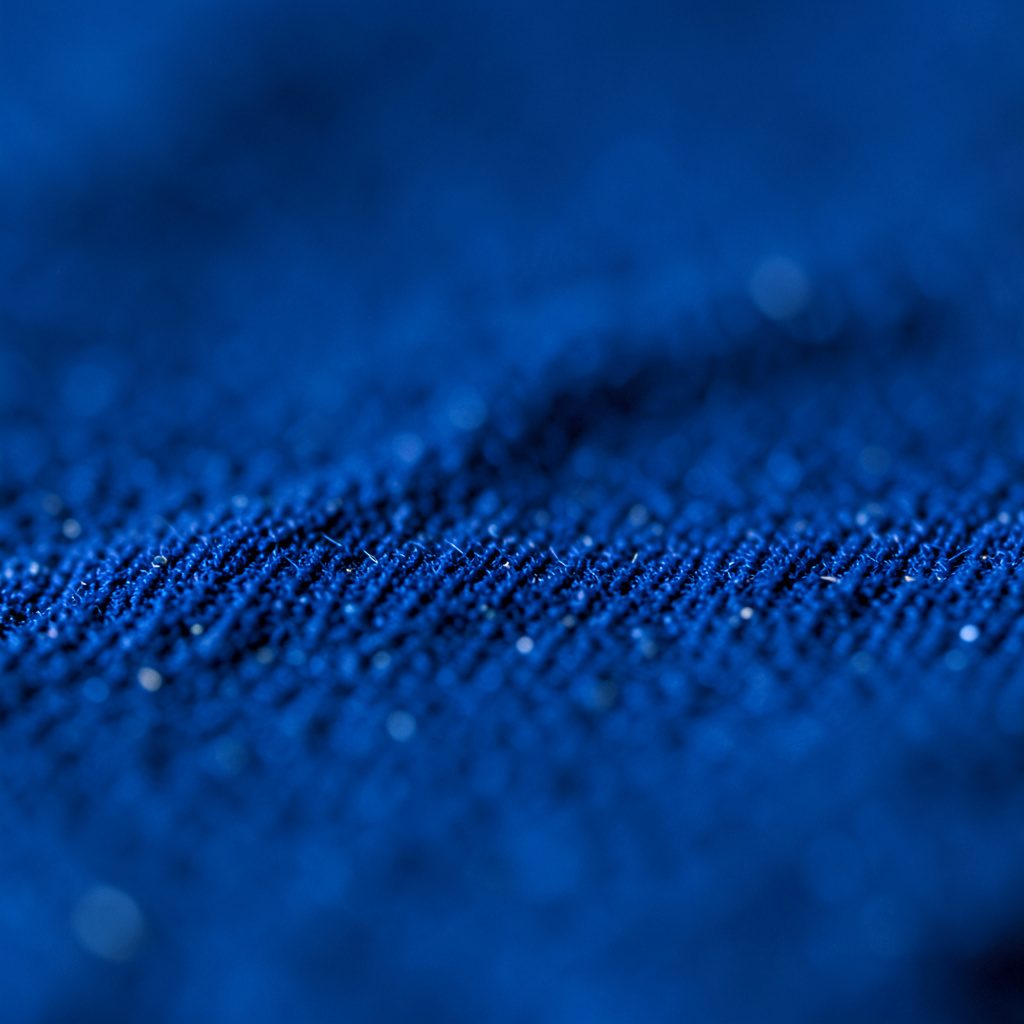 Close-up of a dark blue grid pattern resembling a pixelated screen, navy and black tones