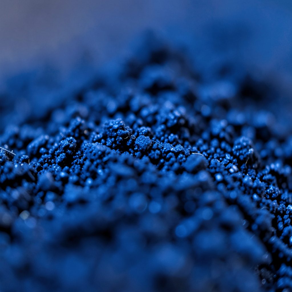 Extreme close-up of a smooth glass surface reflecting blue ambient light, glossy and minimal mood.